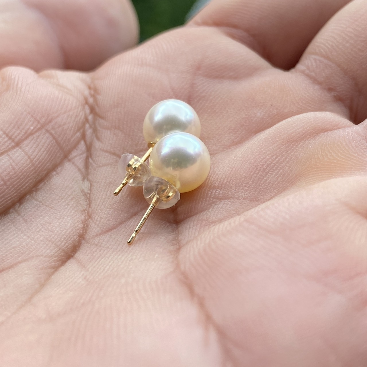 Yuyake pearl earrings shown in hand for scale