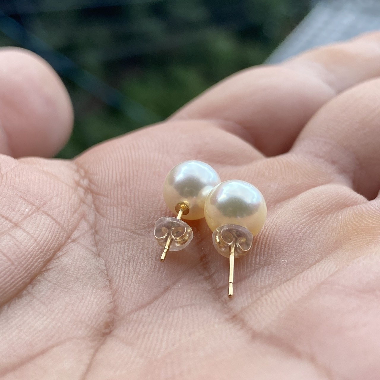 Back view of Yuyake pearl earrings in hand