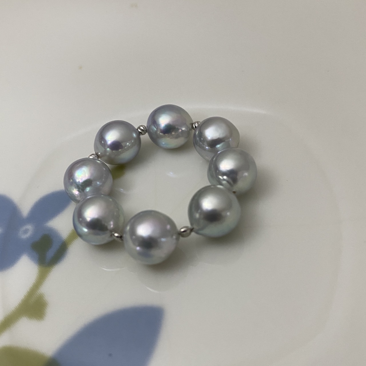 Baroque Akoya pearl ring with blue and pink overtones on a white dish